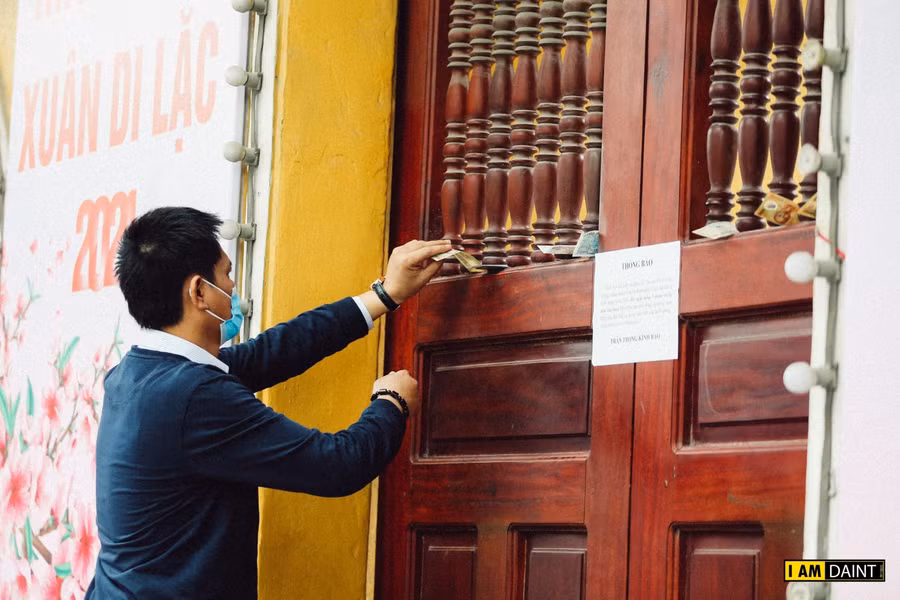 Nhiều người gài tiền lễ ở khe cửa chùa.