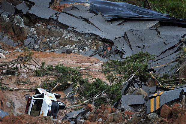 Những thảm họa thiên nhiên, một năm nhìn lại ảnh 8 A vehicle is seen from the edge of a 50-metre-long, 12-metre-deep crater, in Itapevi, west of Sao Paulo, Brazil. The crater was opened by a landslide as a consequence of a heavy summer storm