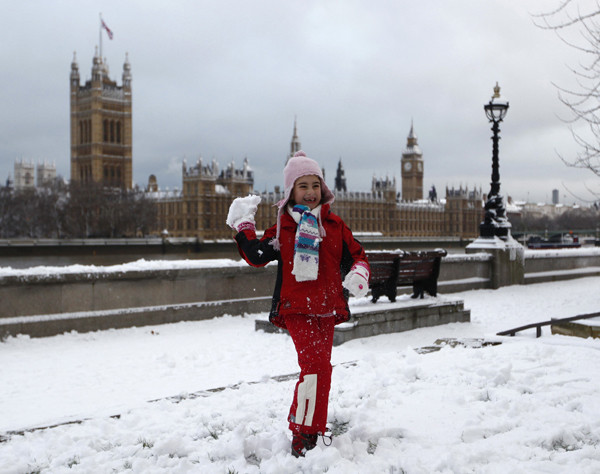 A young girl throws a snowball while posing for a photograph opposite the Houses of Parliament, in central London December 18, 2010. Fresh snow brought much of Britain to a standstill on Saturday, on what is traditionally the busiest weekend for shopping and travel in the run-up to Christmas. 