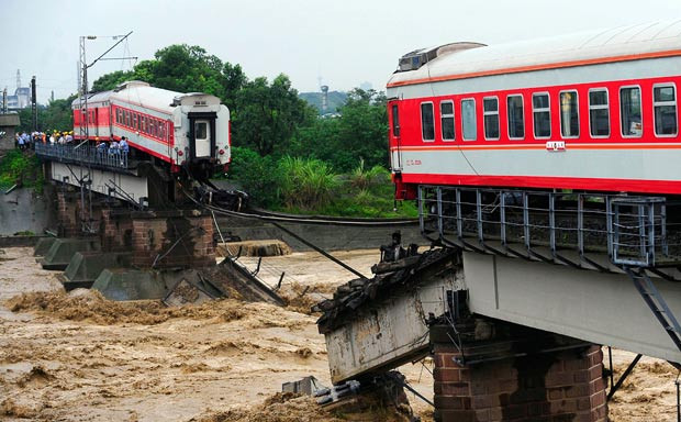 Những thảm họa thiên nhiên, một năm nhìn lại ảnh 15 A passenger train is seen on a partially destroyed railway bridge after two of its carriages fell into the river in Xiaohan town of Guanghan, Sichuan province
