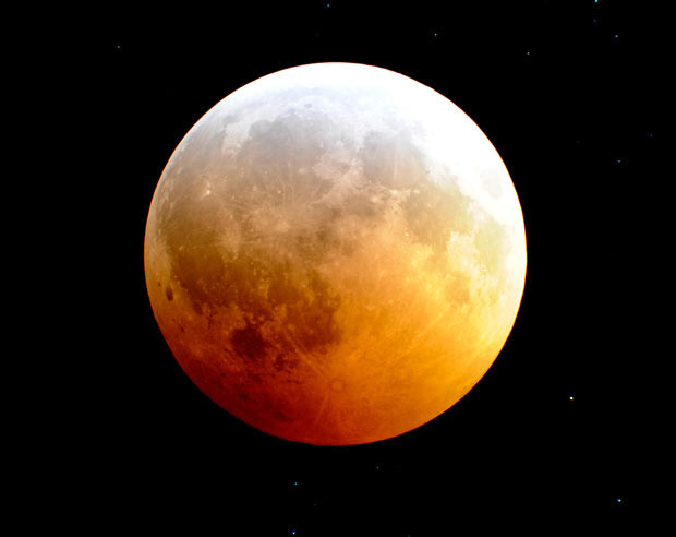 The Moon is engulfed in the Earth’s shadow as it nears the peak of a rare winter solstice total lunar eclipse as viewed through a telescope from Palm Beach Gardens, Florida