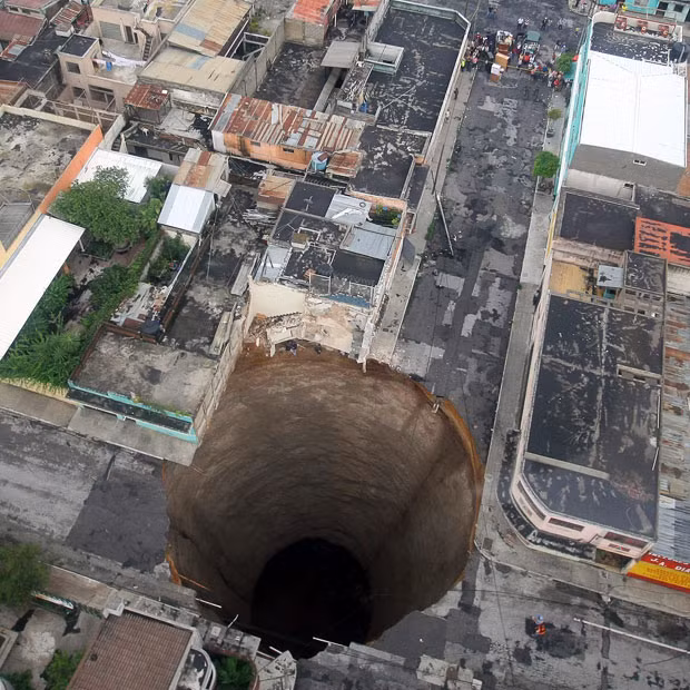 A cavernous and almost perfectly round sinkhole swallowed an entire intersection in Guatemala City during a tropical storm. The hole is 66 feet across and plunges nearly 100 feet down. Geologists said that the circular shape suggested a cave formation underneath, but what exactly caused the sinkhole was still a mystery