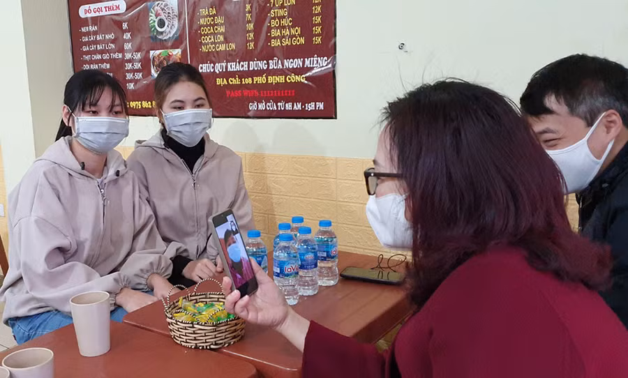 GS TS Nguyễn Thị Nhung - Phó hiệu trưởng Trường ĐH Mở Hà Nội trò chuyện với phụ huynh qua điện thoại khi đến trao quà cho sinh viên ở khu Định Công, trưa 9/1.