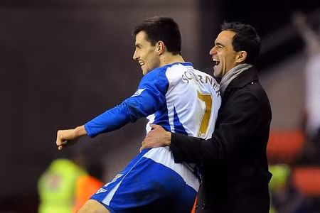 Paul Scharner (số 7) và HLV Roberto Martinez rất hạnh phúc với kết quả đạt được của đội nhà