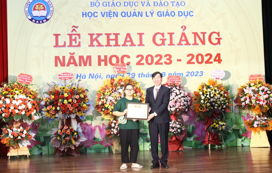 TS Phan Hồng Dương - Phó Giám đốc phụ trách Học viện Quản lý giáo dục trao Giấy khen cho tân sinh viên là thủ khoa đầu vào năm học 2023 - 2024.