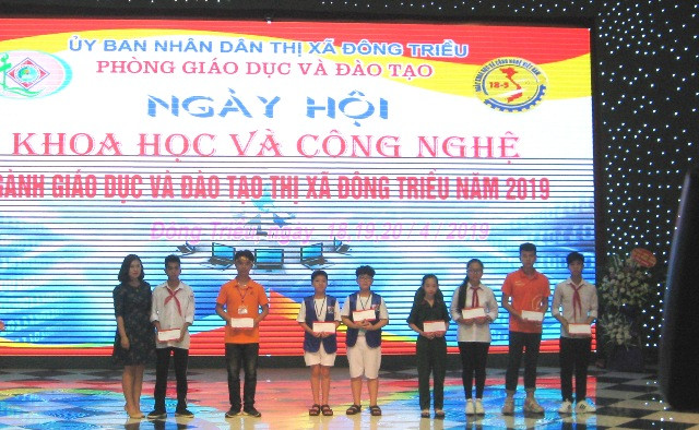Đại diện doanh nghiệp trao học bổng cho học sinh.