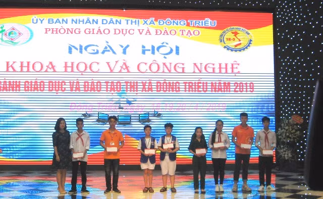 Đại diện doanh nghiệp trao học bổng cho học sinh.