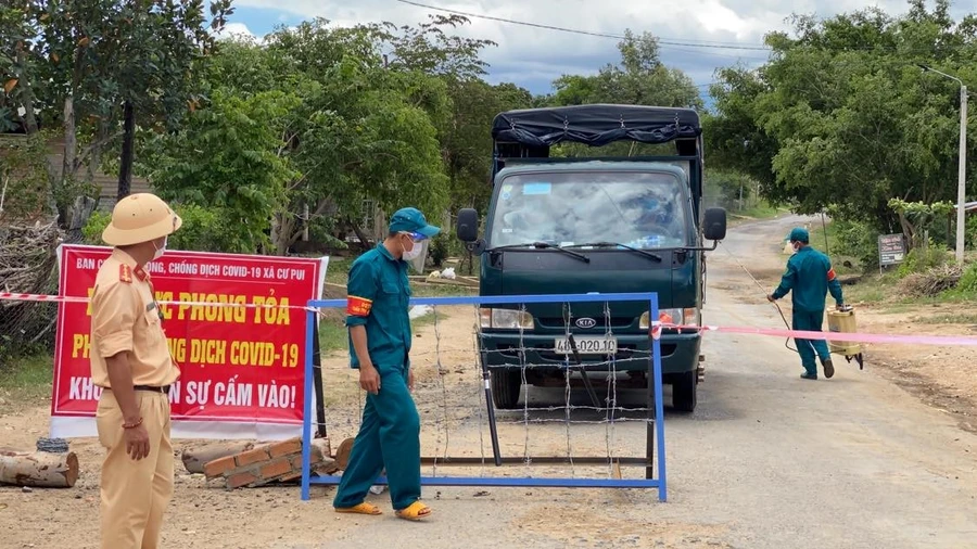 Lực lược chức năng kiểm tra thông tin, phun khử khuẩn các phương tiện chở nhu yếu phẩm hỗ trợ bà con trong khu vực phong tỏa của xã Cư Pui, huyện Krông Bông (ảnh: Thành Tâm).