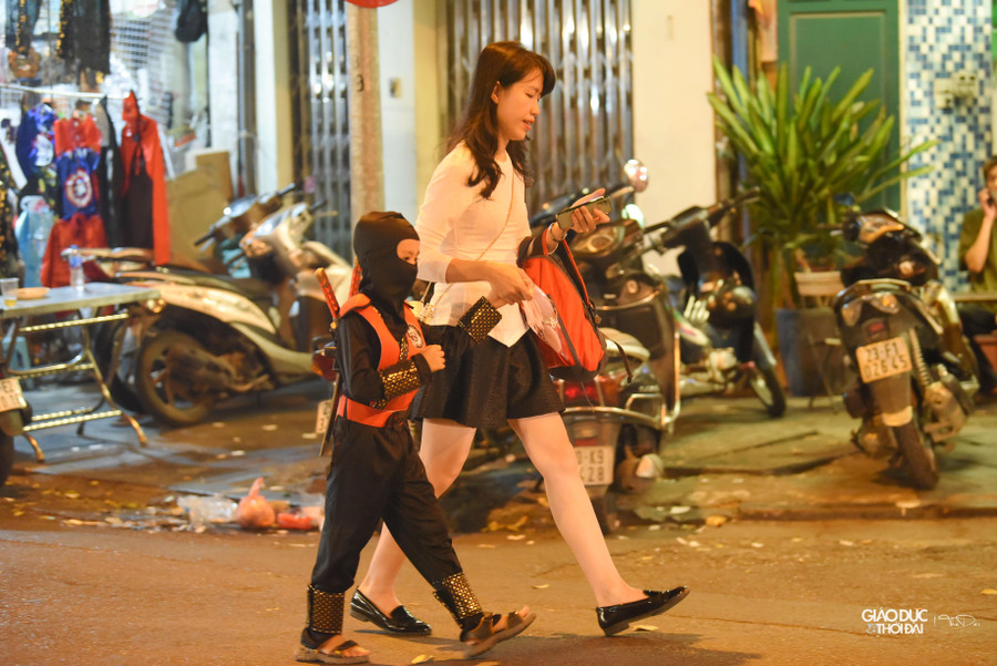 Nhiều bạn nhỏ được gia đình sắm nguyên bộ đồ hóa trang thích thú đi chơi tại khu phố.