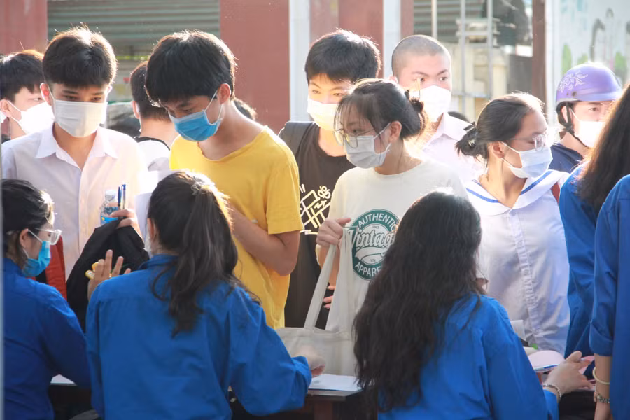 Tình nguyện viên hỗ trợ giữ túi xách và...