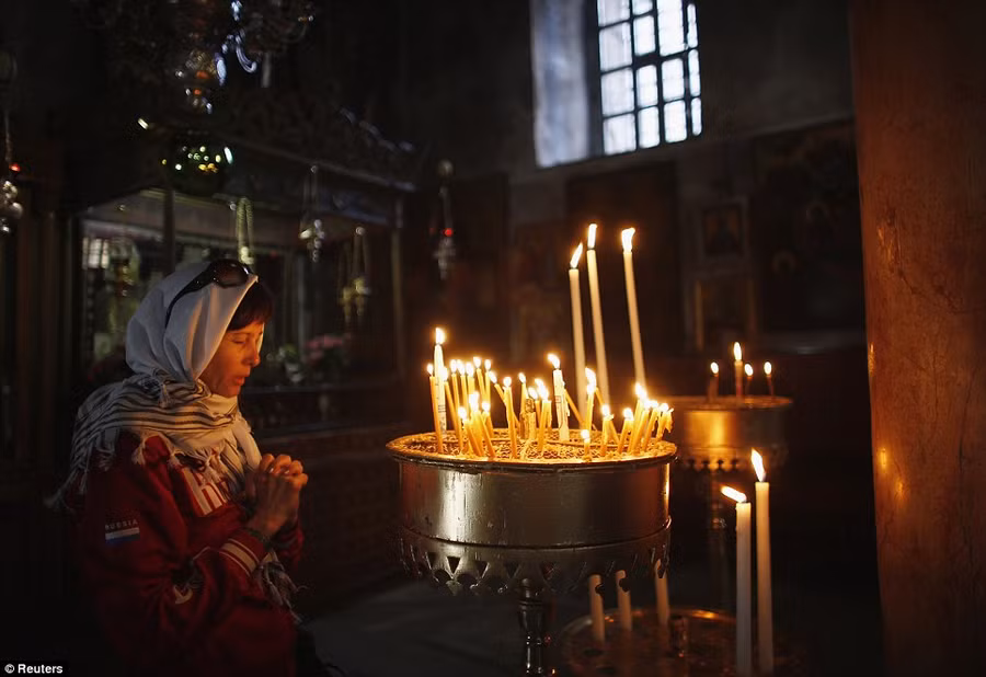 Peace to pray: A visitor prays next to burning candles in the Church of the Nativity Read more: http://www.dailymail.co.uk/news/article-2528947/Crowds-gather-Bethlehem-Christmas-Eve-celebrations-amid-calls-peace-Middle-East.html#ixzz2oS2tOpET Follow us: @MailOnline on Twitter | DailyMail on Facebook