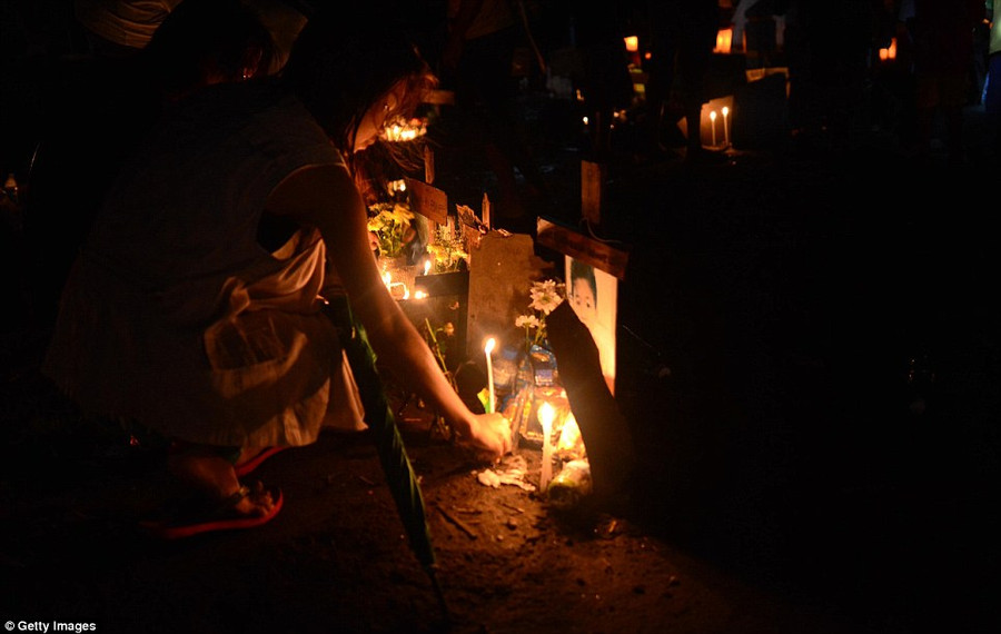 A young girl laces a candle as relatives visit the grave of a loved one who was killed during Typhoon Haiyan at a flooded mass grave on Christmas Eve Read more: http://www.dailymail.co.uk/news/article-2528947/Crowds-gather-Bethlehem-Christmas-Eve-celebrations-amid-calls-peace-Middle-East.html#ixzz2oS3frX2q Follow us: @MailOnline on Twitter | DailyMail on Facebook