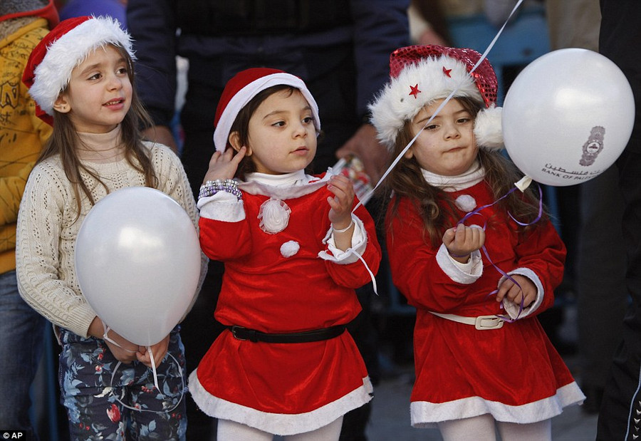 Palestinian children dressed up as Santa Claus pose for a photograph at Manger Square Read more: http://www.dailymail.co.uk/news/article-2528947/Crowds-gather-Bethlehem-Christmas-Eve-celebrations-amid-calls-peace-Middle-East.html#ixzz2oS32rqc3 Follow us: @MailOnline on Twitter | DailyMail on Facebook