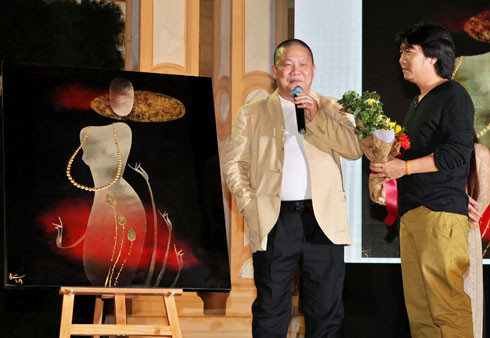 Họa sĩ Đinh Quân (phải) trao hoa cho vị mạnh thường quân mua bức Trinh nữ của anh với giá 210 triệu đồng.