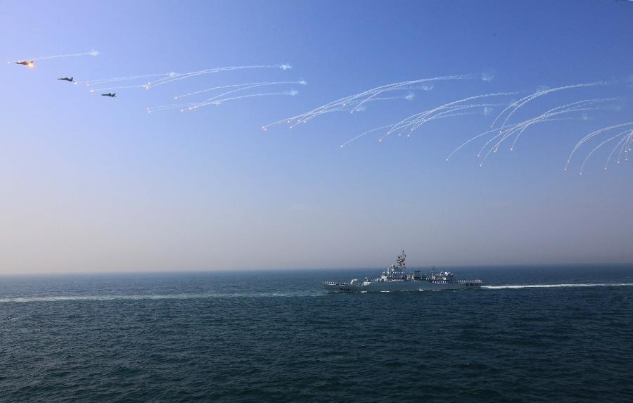 A naval vessel and aircrafts are seen during the fleet review of the Russia-China joint naval exercise in the Yellow Sea of the Pacific Ocean, April 26, 2012. Chinese and Russian warships concluded a live ammunition exercise on Thursday, following a no-weapon joint war game earlier the same day.