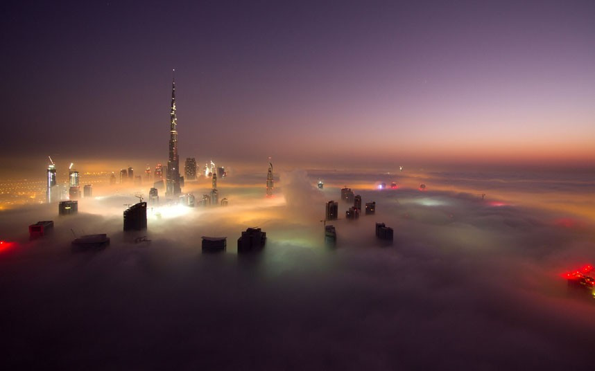 The world’s tallest building, Dubai’s 2,700ft-high Burj Khalifa, appears through of a carpet of fog in this image taken by a British property developer from the roof of a 800 foot-tall residential building