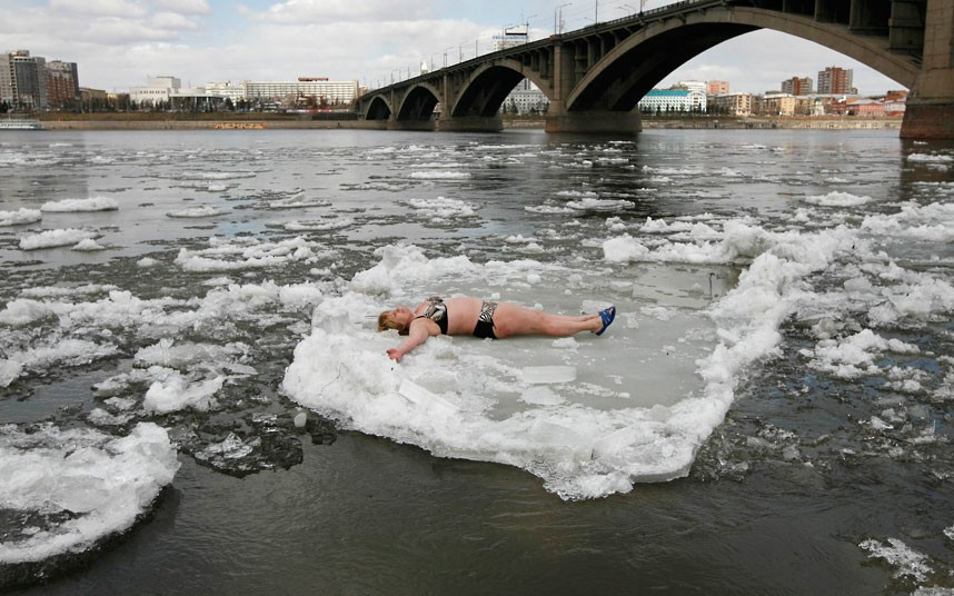 A member of the Cryophil winter swimmers club lies on floating ice on the Yenisei River in the Siberian city of Krasnoyarsk