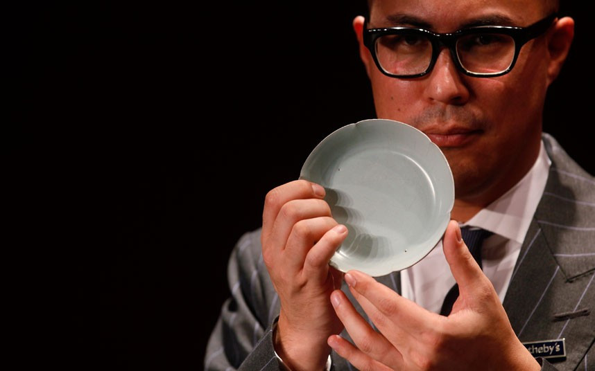 Nicolas Chow, Sotheby’s Asia Deputy Chairman, holds the Chinese Song Dynasty ceramics Ruyao Washer at the Sotheby’s auction in Hong Kong. The 900-year-old dish smashed the world record for Chinese Song Dynasty ceramics sold at auction, fetching US$26.7 million (£16.8 million)