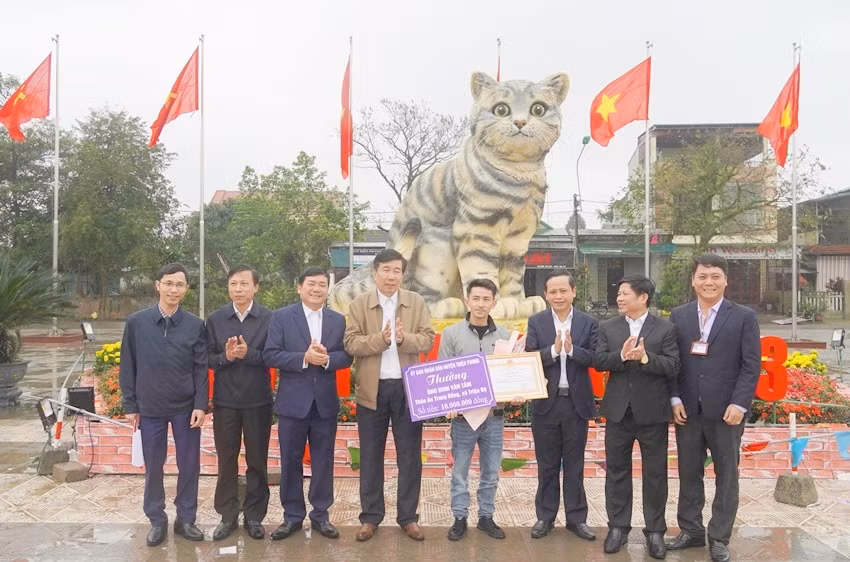 Lãnh đạo huyện Triệu Phong khen thưởng nghệ nhân tạo ra tượng mèo. (Ảnh: Tiến Nhất).