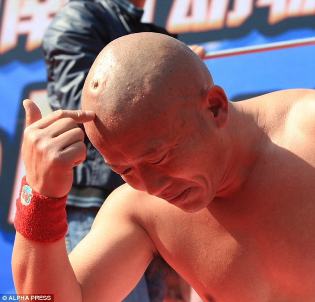 Li leans forward to show the indentation that the spike leaves on his skull. He has spent more than 20 years perfecting his craft Read more: http://www.dailymail.co.uk/news/article-2070586/Stuntman-Li-Xin-balances-nail-head.html#ixzz1fqJyP12n