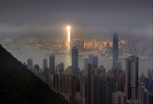 A bright beam of sunlight illuminates one of the tallest buildings in the world - the 1,588ft tall, 108-floor International Commerce Centre in Hong Kong - while leaving the rest of the cityscape in cloudy darkness. The moment was captured by keen Russian photographer Pavel Kiselev.