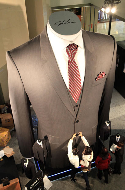 Chiếc áo cao 6,5 mét tại một khu mua sắm ở tỉnh Sơn Tây, Trung quốc People look at a giant 6.5m tall suit mannequin in a shopping mall in Taiyuan, Shanxi Province, China