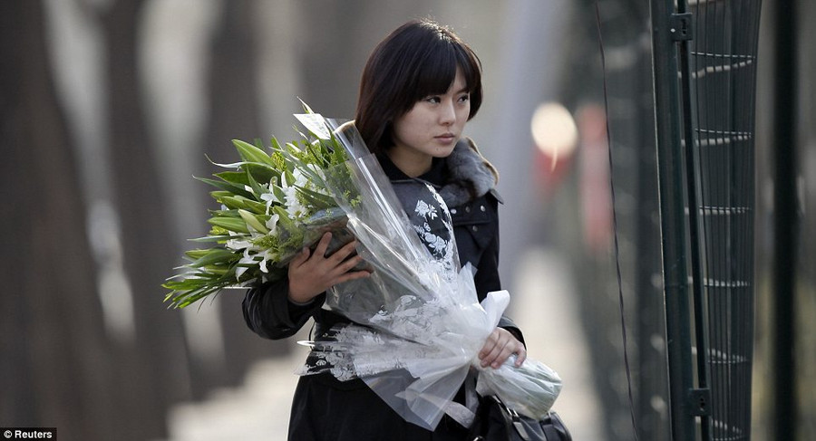 A woman holding flowers walks through a fence to enter the North Korea embassy to mourn the death of Kim Jong-il in Beijing, China Read more: http://www.dailymail.co.uk/news/article-2075987/Kim-Jong-Il-dead-North-Korea-leader-dies-heart-attack-69.html#ixzz1gzY0FxKg