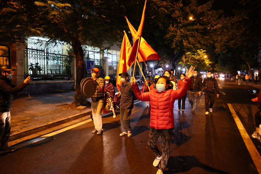 Người dân sinh sống trên phố Phủ Doãn vui mừng phất cờ.