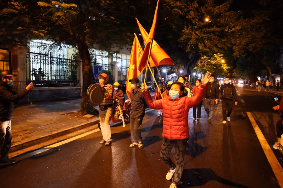 Người dân sinh sống trên phố Phủ Doãn vui mừng phất cờ.