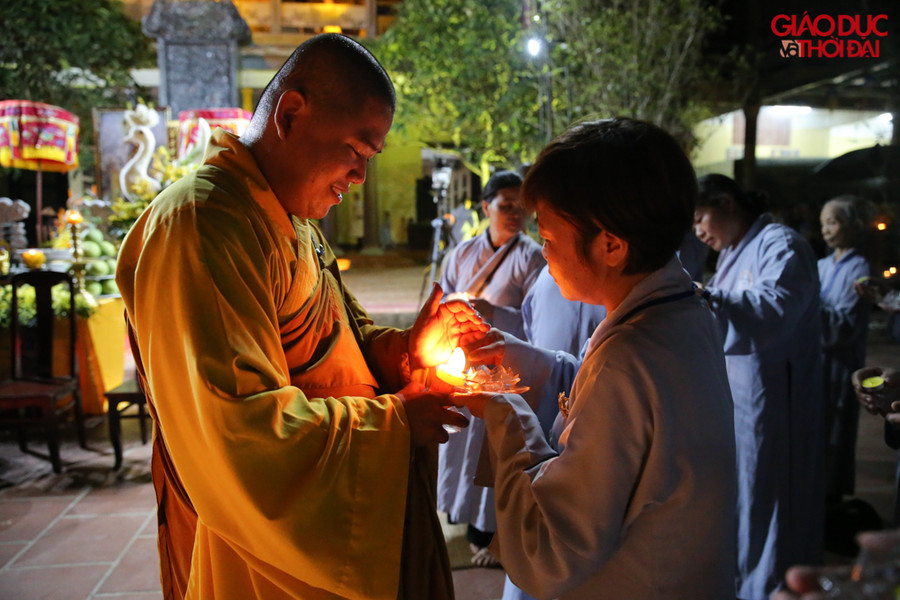 Từ một ngọn nến, các sư thầy chùa Hòa Phúc truyền lửa đến hoa đăng trên tay từng Phật tử.