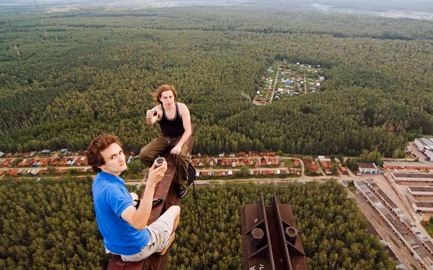 Daredevils enjoy a drink on top of an abandoned radio tower in Moscow, Russia. Russian roof-topper Max Polazov, 22, took a series of vertigo-inducing shots with the help of his band of danger-addicted friends.