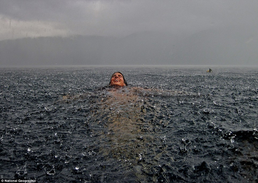Photographer Camila Massu said: ’My sister in the south of Chile. We are sitting at home next to the fireplace in our southern lake house when it suddenly began to pour uncontrollably. Had to rush into the lake to take this snapshot!’ Read more: http://www.dailymail.co.uk/news/article-2189479/National-Geographic-reveal-winners-2012-Photo-Contest.html#ixzz23mCPAZTp