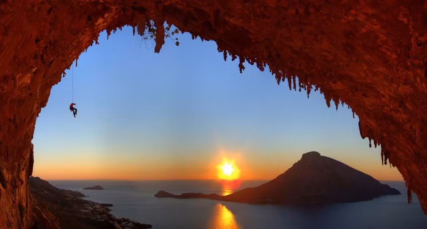 A rock climber watches the sun setting over the sea. Amateur photographer Mike Meysner took this shot from the outlook of a cave at the water