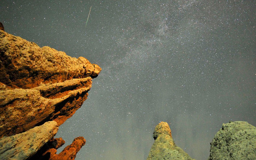 Những hình ảnh ấn tượng trong tuần ảnh 3 A meteor streaks past stars in the night sky over rock formations near the village of Kuklici in Macedonia, during the annual Perseid meteor shower