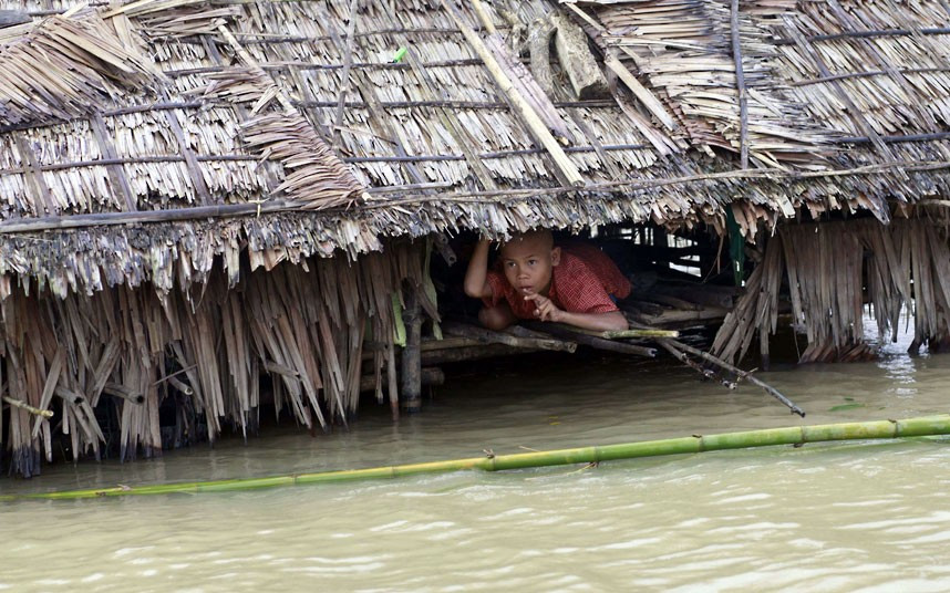 A boy looks out from his partially-submerged house in the Irrawaddy delta region of Myanmar. Recent heavy monsoon rains have left swathes of farmland flooded in many parts of the country.