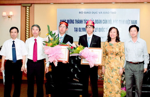 Ngô Phi Long (thứ 3 từ trái sáng) nhận bằng khen và hoa chúc mừng của Thứ trưởng Bộ GD-ĐT Nguyễn Thị Nghĩa