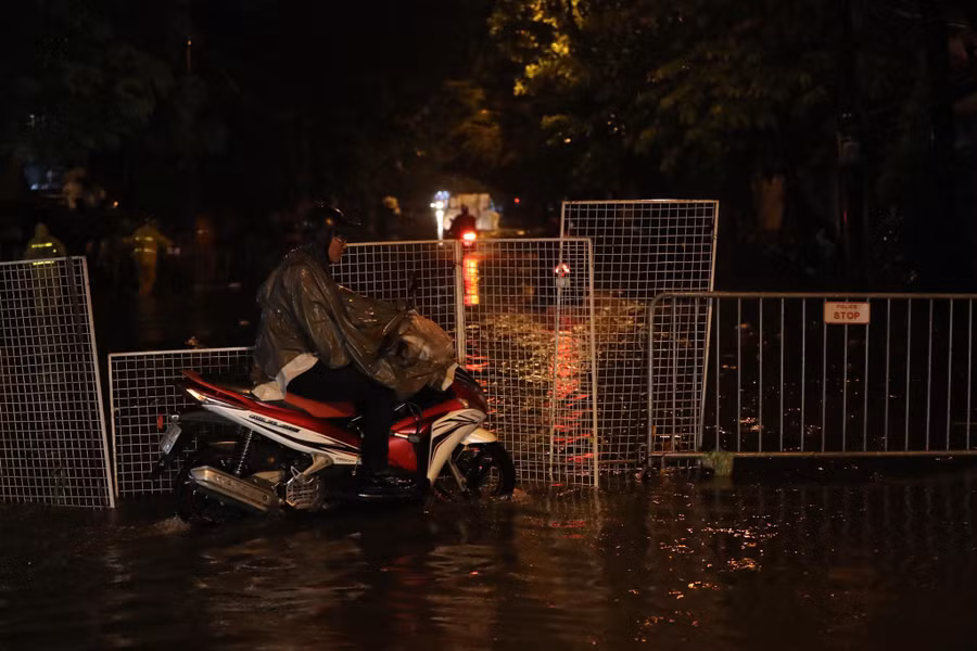 Để cảnh báo các phương tiện đi vào vùng nước sâu, người dân mang cả hàng rào ra để chắn giữa đường.