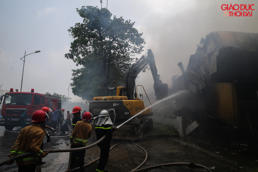Khu nhà xưởng quây bằng tôn và tưởng quây, nên lực lượng đã điều động máy xúc để phá tường