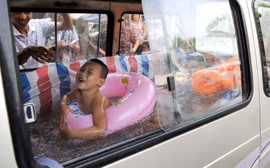 Những hình ảnh ấn tượng trong tuần ảnh 4 Zhou Yuhang plays in a mobile swimming pool which his father built in the back of a van, in Wenzhou city, Zhejiang province, east China. The child’s father removed the seats of a van and lined it with plastic.