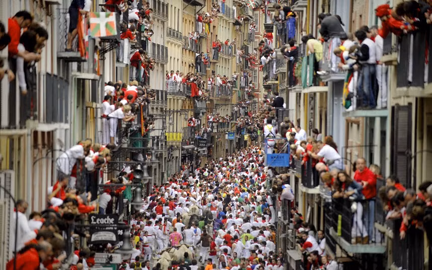 Những hình ảnh ấn tượng trong tuần ảnh 7 People on balconies watch the fifth San Fermin Festival bull run