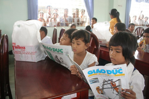 Các em HS đang cùng nhau xem Báo Giáo dục và Thời đại