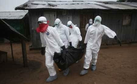 Các nhân viên y tế đang di dời một xác người thiệt mạng vì virus Ebola ở Liberia. Ảnh: Getty Images Các nhân viên y tế đang di dời một xác người thiệt mạng vì virus Ebola ở Liberia. Ảnh: Getty Images