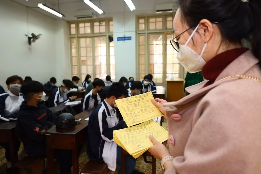 Các em được phát chứng nhận tiêm chủng ngừa Covid-19.