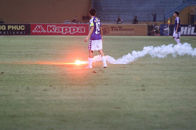 Những quả pháo sáng liên tục " bay" xuống dưới sân.