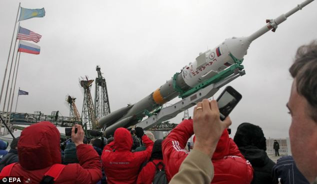 Nga phóng tàu vũ trụ kỷ niệm 50 năm Gagarin bay vào không gian ảnh 4 Onlookers take a snap as the Russian Soyuz TMA-21 rocket is mounted Read more: http://www.dailymail.co.uk/sciencetech/article-1372645/Russia-prepares-launch-Soyuz-space-ahead-50th-anniversary-manned-flight-Yuri-Gagarin.html#ixzz1ITSzhIvl