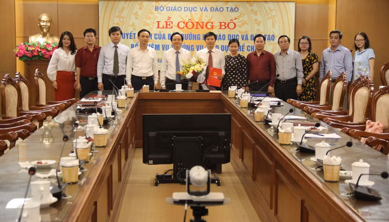 Bộ trưởng Phùng Xuân Nhạ và các đại biểu tặng hoa chúc mừng tân Vụ trưởng Vụ Giáo dục thể chất.