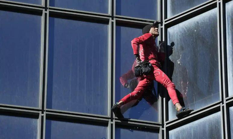Ông Alain Robert leo núi mà không cần dây an toàn, chỉ cần giày leo núi và một túi phấn bột. Ảnh: Michel Euler/AP. Ông Alain Robert leo núi mà không cần dây an toàn, chỉ cần giày leo núi và một túi phấn bột. Ảnh: Michel Euler/AP.