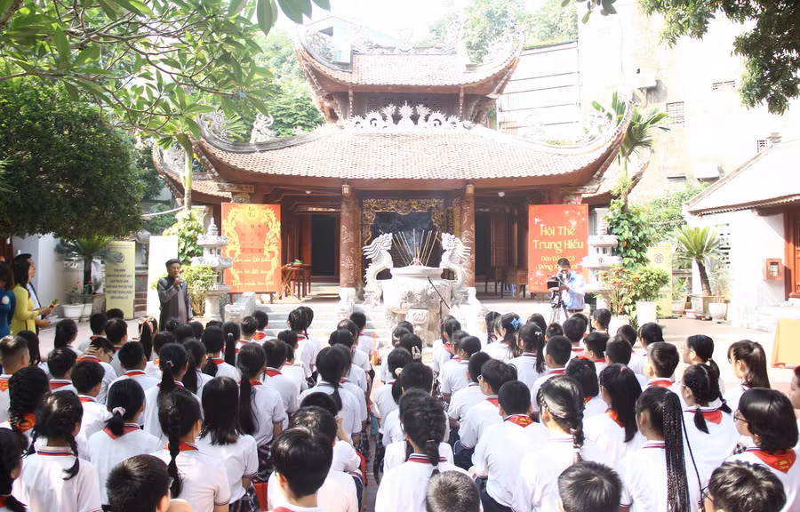 Thầy - trò Trường tiểu học Đông Thái được nghe về lịch sử, ý nghĩa của Lễ hội đền Đồng Cổ và Hội thề Trung Hiếu. (Ảnh: Lê Nghĩa)