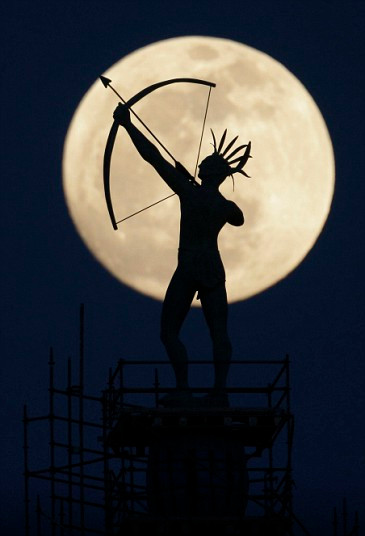 Trăng tròn mọc phía sau 1 bức tượng ở Topeka (Mỹ) A full moon rises behind a statue of a Kansas Indian on top of the Kansas Statehouse in Topeka, Kan.