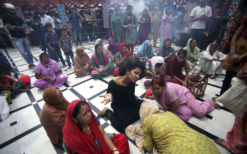A Hindu devotee whirls her head in a trance at the historical Kali Temple during Navratri festival in Jammu, India. Navratri, or the festival of nine nights, is dedicated to the worship of various goddesses